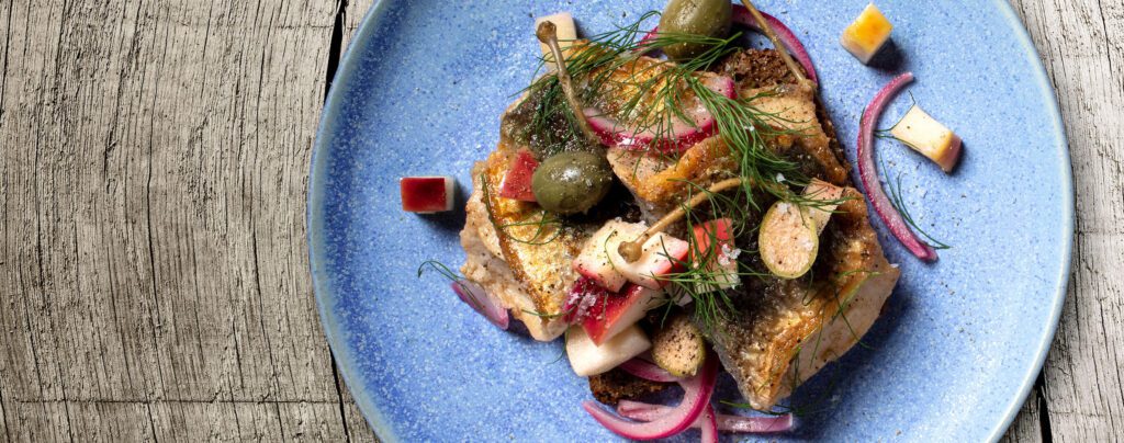 Stekt inlagd sill med pepparrot, äpple och rödlök data-image-src="https://vildmedsild.dk/wp-content/uploads/2019/10/Problemløser_TopView_Dish3_2740x1080-1.jpg"