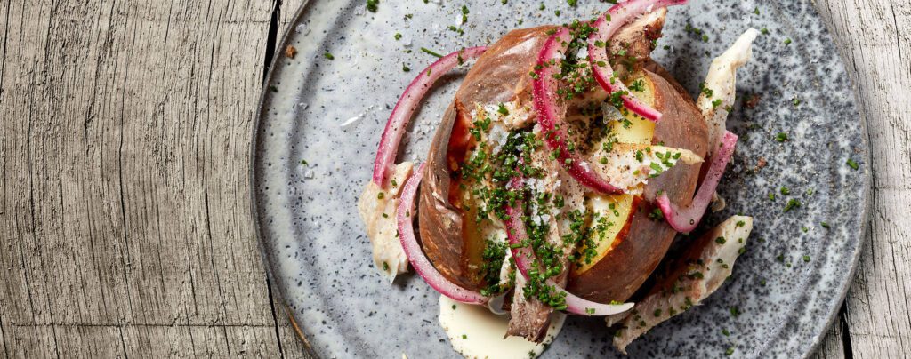 Bakad potatis med rökt sill, crème fraiche, gräslök och rödlök Problemloeser TopView Dish7 2740x1080 1 1024x404